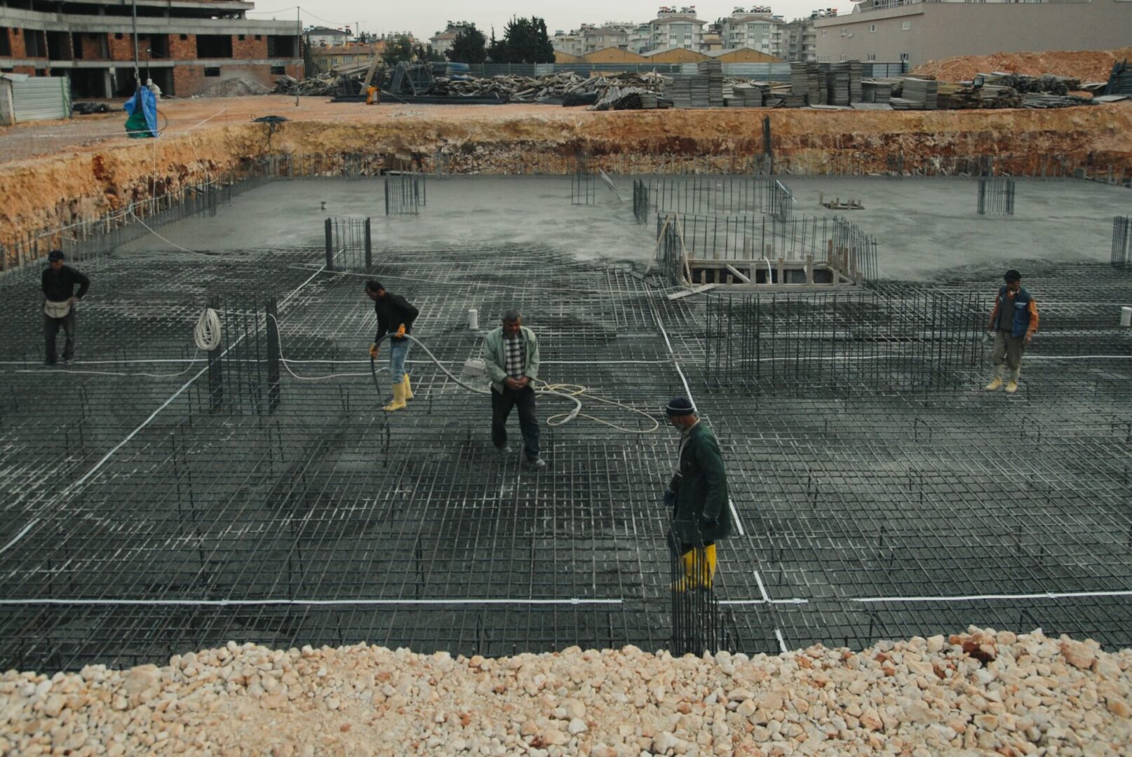 A group of men working on concrete in the middle of construction.